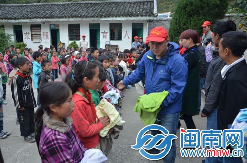 赖金土和志愿者给孩子们发衣物