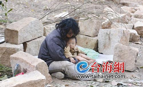 女子带小孩睡地上