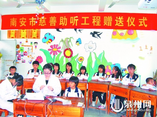 工作人员为失聪儿童安装助听器