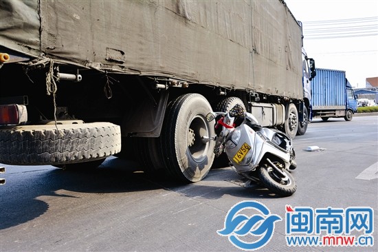 记者赶到现场时，摩托车倾倒在大货车的右后轮旁
