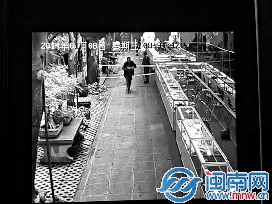 一黑色外套男子手持物品跨过警戒线进入场内