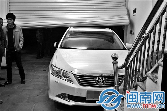 轿车冲破卷帘门闯进屋内