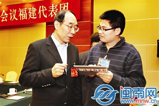 尤权书记通过本报特派记者手中的iPad，浏览读者、网