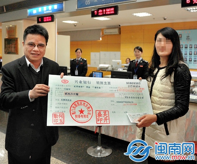 许女士从厦门市地税局局长吴振坤手中接过20万元的“