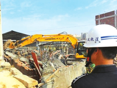 大型钩机对违法建筑进行强制拆除