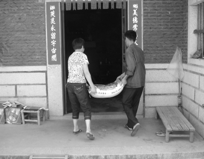 刘小川正在为鼎诚村的困难户送米