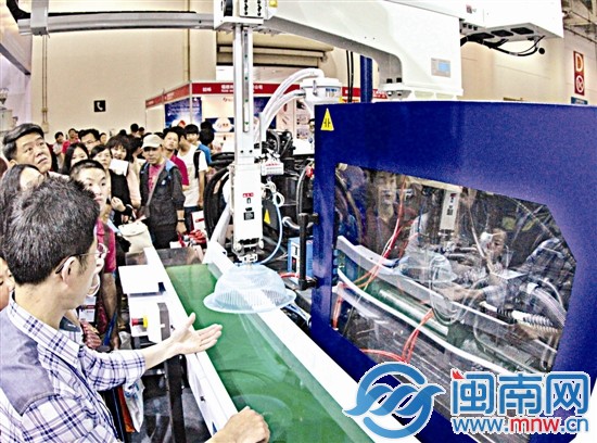 在台交会展馆，注塑机现场生产塑料盆，吸引很多市民