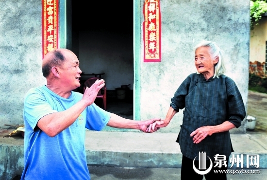 临别时，卖煤工刘逸强（左）叮嘱陈喜老人注意饮食起