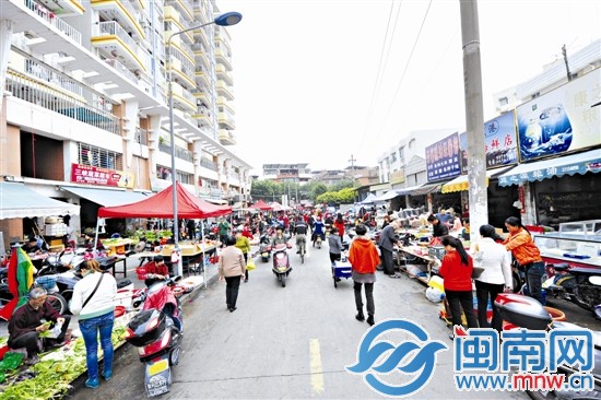 道路两侧摆满摊位,让整条路拥挤不