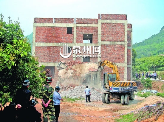 挖掘机对违建别墅进行破除