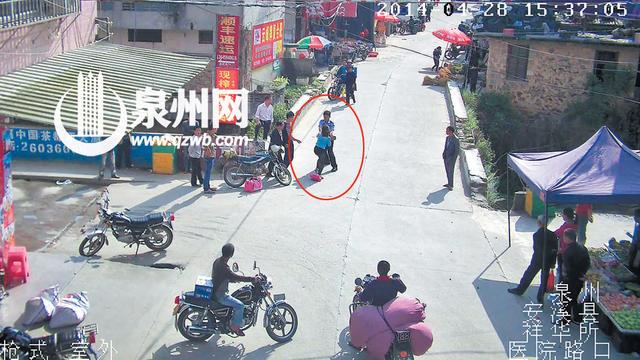 雷某（蓝衣女子）双手狠抓协警的手臂 （图中画红圈