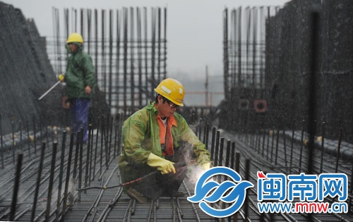 泉州跨海大桥桥面上的工人雨中电焊钢筋