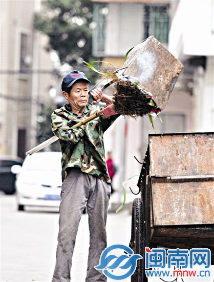 将滴着污水的垃圾装上车还是有点吃力