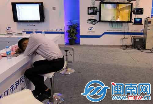 一位工作人员趴在前台上休息