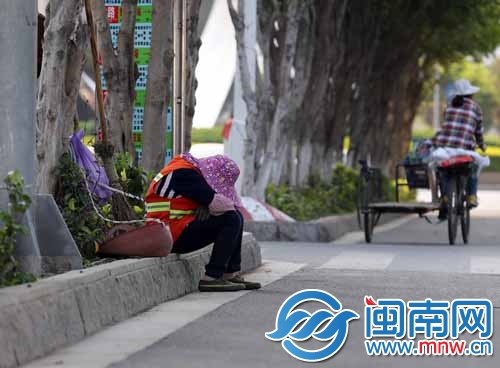 一位环卫工人坐在路边休息