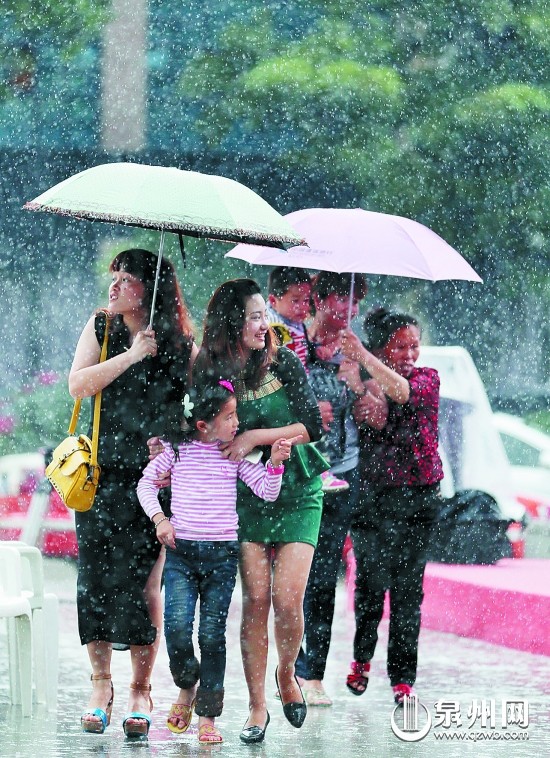 在泉州市区宝洲街，市民雨中出行