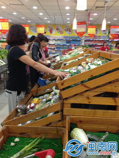 泉秀街一超市蔬菜买一送一,多位主妇正在选购