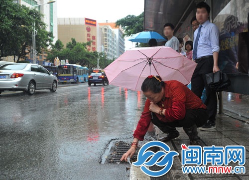 吴阿婆在泉秀街捡垃圾疏通雨水井口