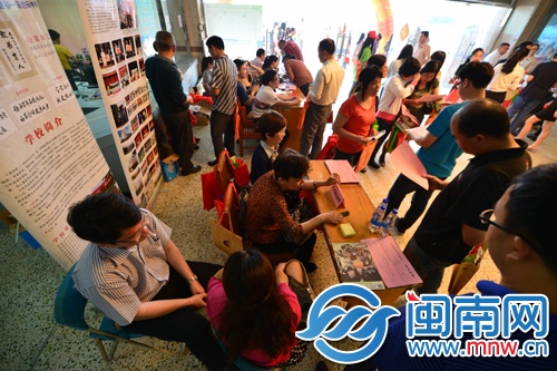 咨询会上,家长向学校招考老师咨询孩子的升学问题