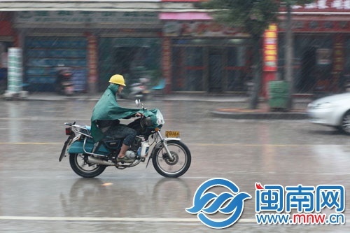 泉州浮桥街上,男子雨中奔波