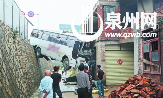 大客车撞上民房后，车身悬空