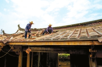 工人在铺设孝友第屋顶上的瓦片。