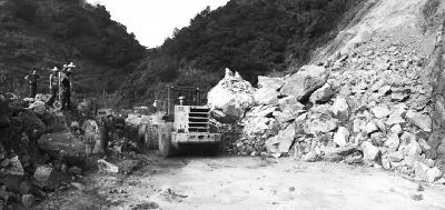 公路抢修人员和机械正在抢修清理溜方