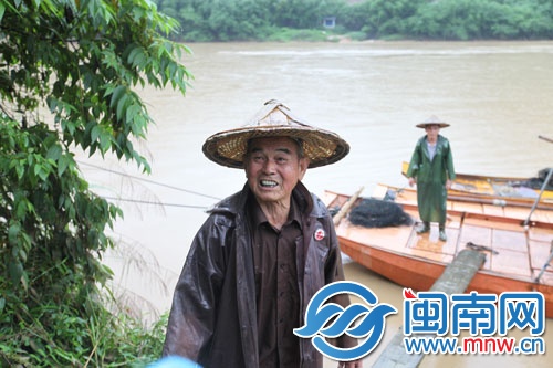 75岁的村民阮永进,开着身后的渔船,救起三名落水者