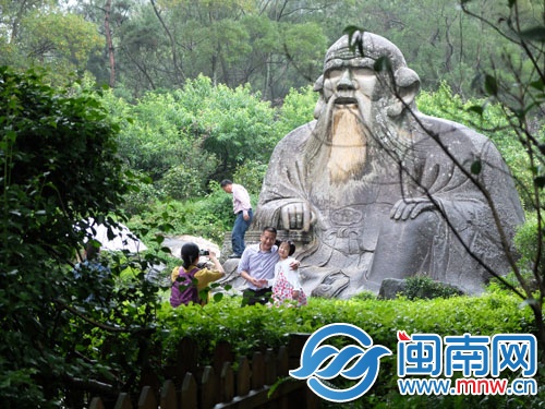 一游客爬上老君岩拍照