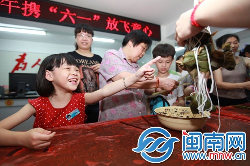 孩子开心地指着自己包好的粽子