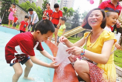 市第二幼儿园孩子与家长一起玩抓泥鳅。