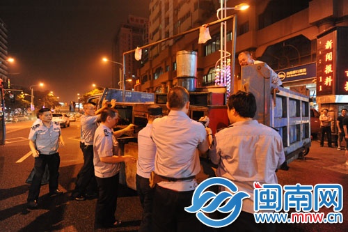 执法人员在泉秀街沉洲路口没收占道的烧烤摊