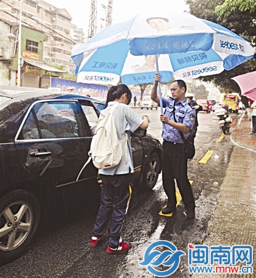 厦门一中考场外,一名民警帮考生撑伞