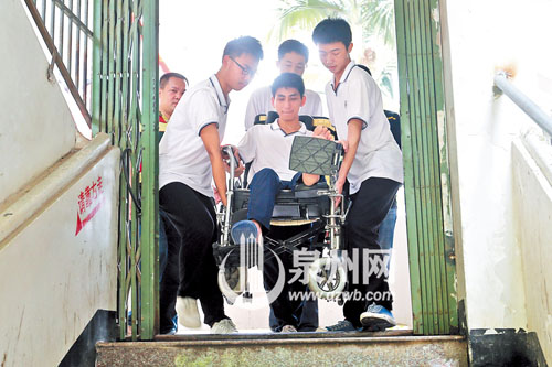 许同学坐在轮椅上，行动不便，三四个同学一起将他抬