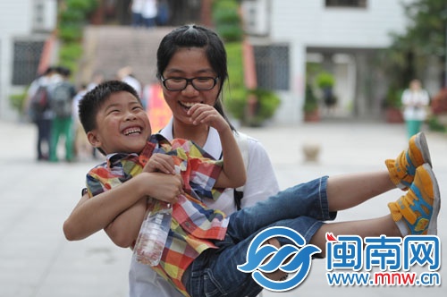 在泉州五中门口，一名考生将在考场外等候的弟弟抱起