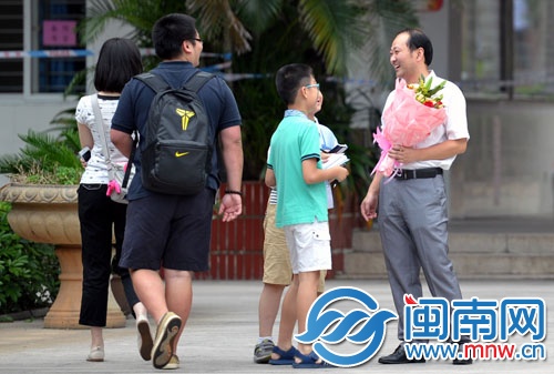 一位老师从自己的学生手中接过鲜花