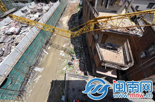 断裂塔吊横架民房上，楼下行人有惊无险