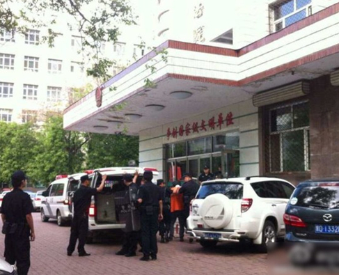 两名犯罪嫌疑人头戴面罩，被法警押进法庭。2