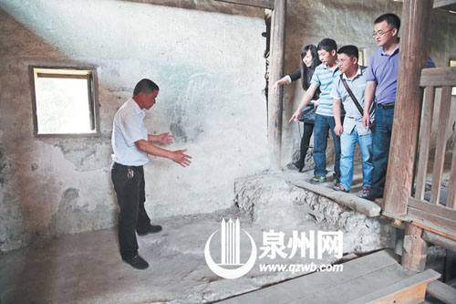 许进丁向游客们比划着土楼墙体的厚度，当年建造土楼