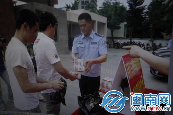 受害人陈先生从民警手中领回被骗的40万元