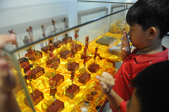 幼儿园小朋友好奇地盯着精致的妆糕人工艺品