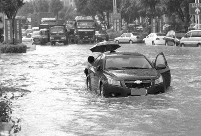 车主正在推行在积水中熄火的车辆