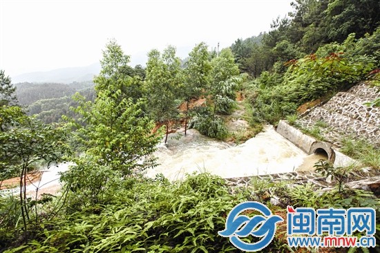 护坡塌方后,水流急速地从涵道口涌出