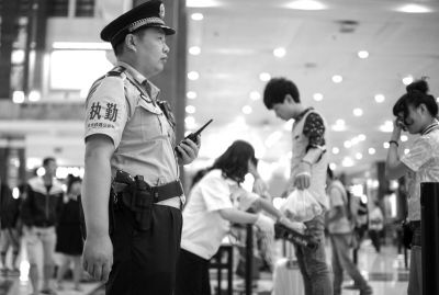 铁路民警在北京站内巡逻，腰间佩带着警用转轮手枪