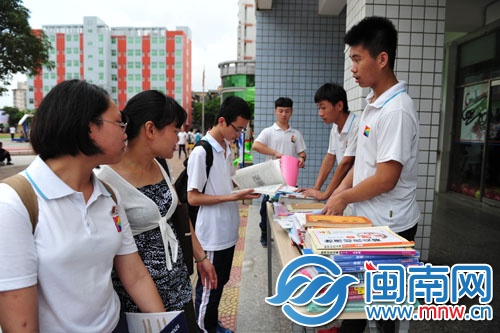 初一初二的学弟学妹在毕业送书摊点前挑选自己想要的