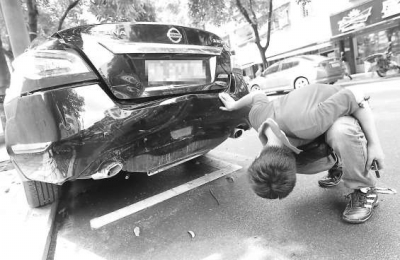 林先生查看受损的爱车。