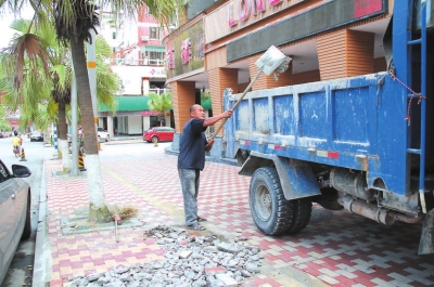 在市区长安街，工人正在清理路面修补后遗留下来的垃