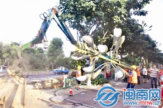 大坑边的一座路灯暂时被拆卸，压桩机正在打桩