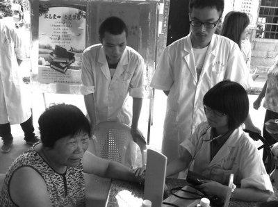 社会实践活动小组成员为黄碧莲阿婆量血压。