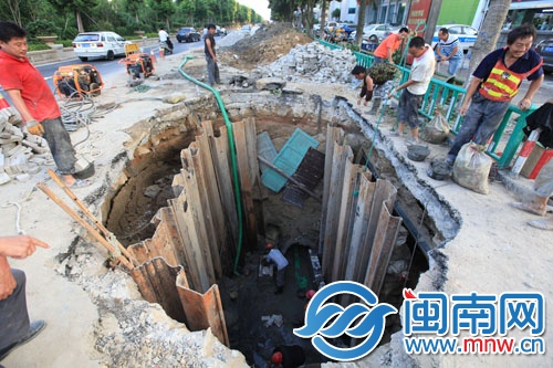 工作人员下到坑底修复